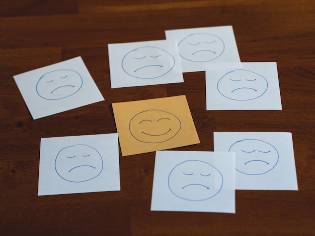 Photo close-up of text notes with happy face among sad faces