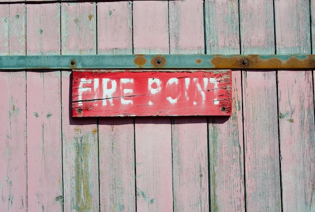 Photo close-up of text on red placard over wooden wall