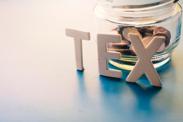 Photo close-up of text with coins in container on table