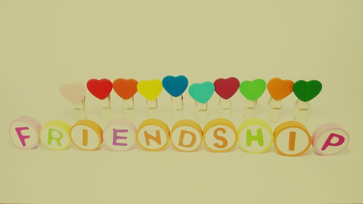 Photo close-up of text with colorful heart shapes against yellow background