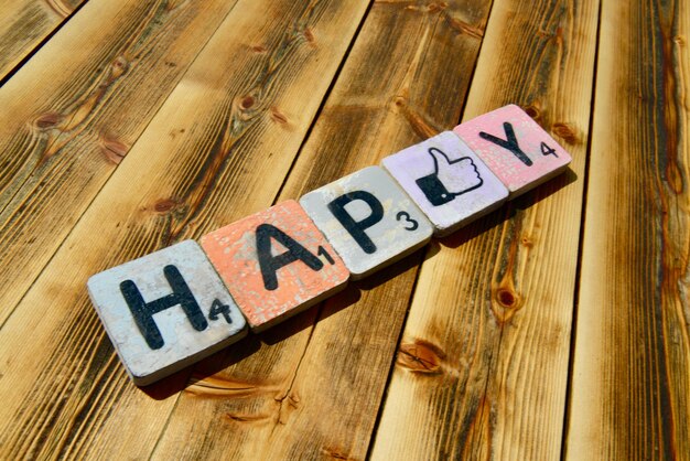 Photo close-up of text with thumbs up sign made with toy blocks on wooden table