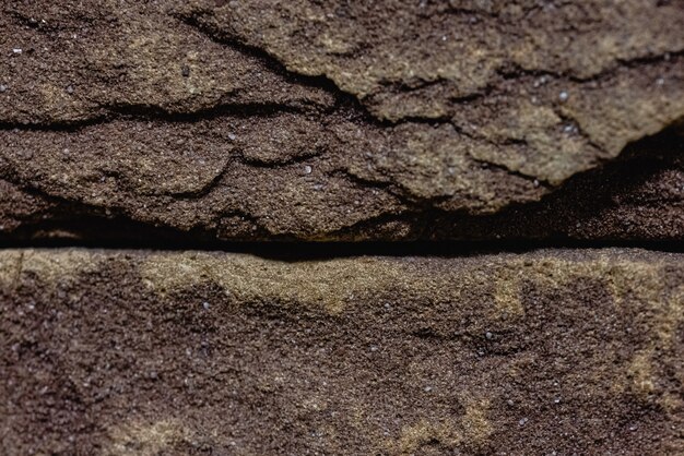 Close-up texture of a brown scratched brick with a gap