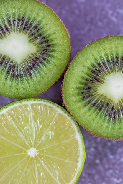 Close-up on the texture of cut fruit kiwi and lime top view.