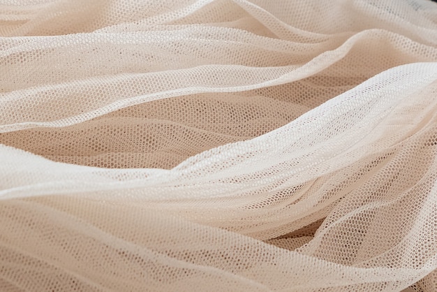 Close up texture of ivory tulle textile, background