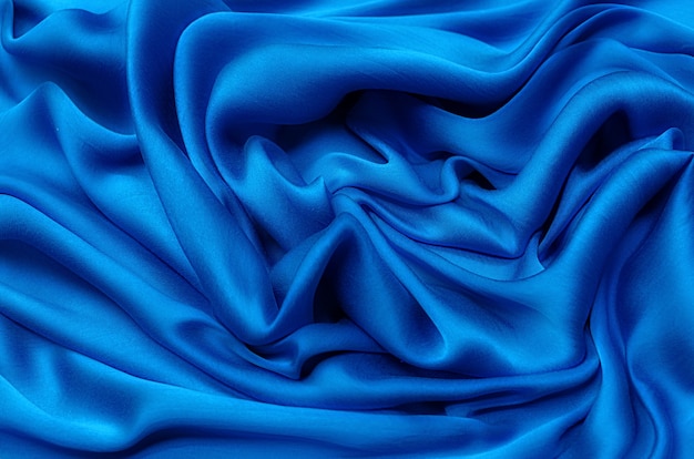 Close-up texture of natural blue fabric or cloth in same color. Fabric texture of natural cotton or silk or wool textile material. Blue canvas background.