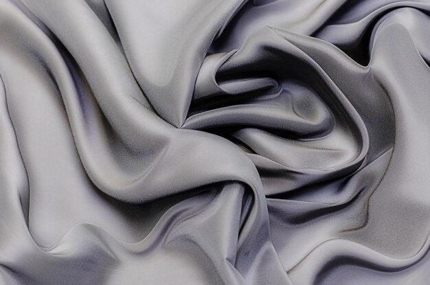 Close-up texture of natural gray or black fabric or cloth in same color. Fabric texture of natural cotton, silk or wool, or linen textile material. Black canvas background.