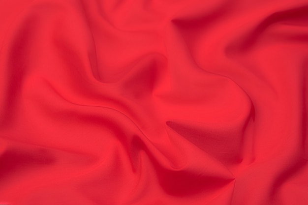 Close-up texture of natural red or pink fabric or cloth in same color. Fabric texture of natural cotton, silk or wool, or linen textile material. Red and pink canvas background.