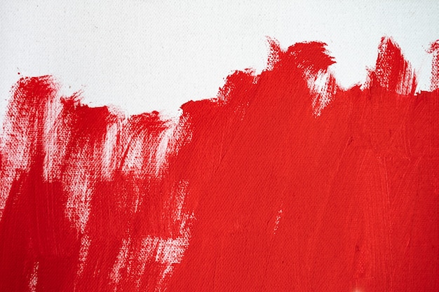 Primo piano texture vernice di colore rosso su tela di colore bianco tratto di segni di pennello per la progettazione grafica della carta sullo sfondo