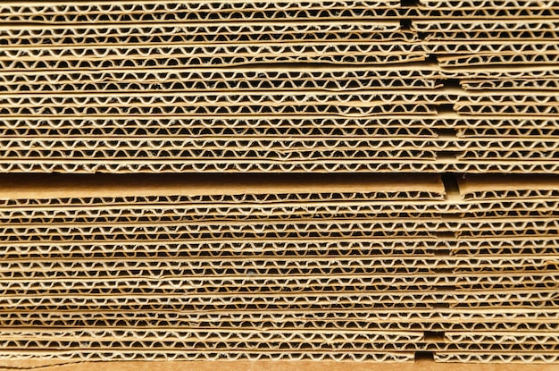 Close-up texture of stacked sheets of craft corrugated cardboard. Recycled materials, sustainable packaging. No waste. corrugated cardboard for packing, Pile of pile of paper box.