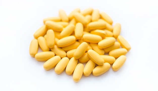 Close-up textuur van gele multivitamine tabletten op witte achtergrond Gezonde levensstijl concept
