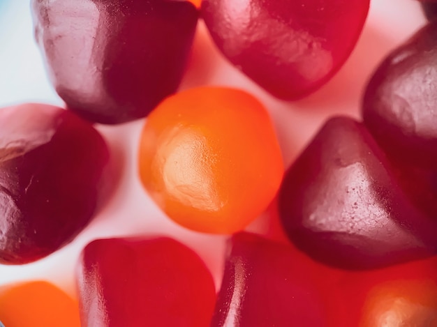 Foto close-up textuur van rode, oranje en paarse multivitamine gummies. gezond levensstijlconcept.