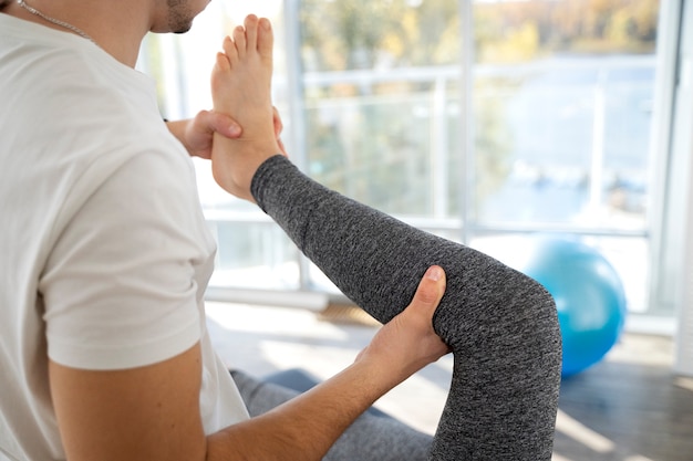 Close up therapis holding patient's leg