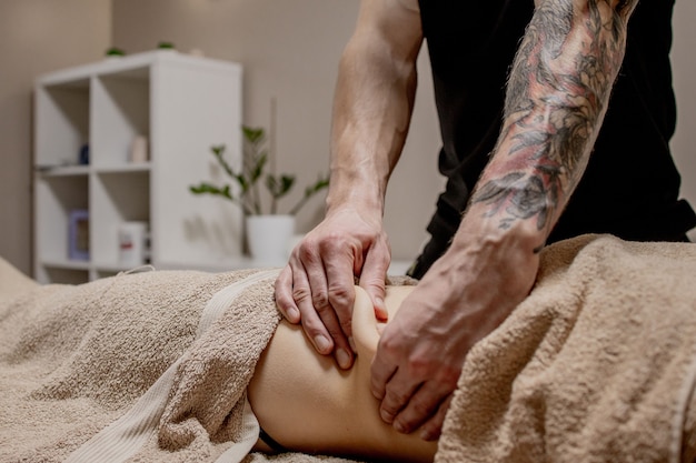 Close up of therapist doing stomach massage on woman in spa.