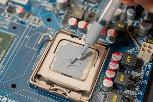 Primo piano composto termico sul chip della cpu nel computer della scheda madre