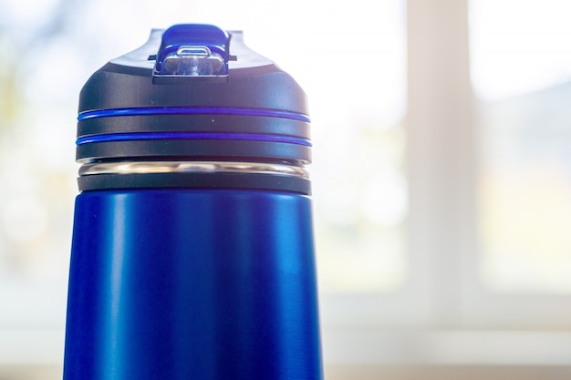 Foto chiuda in su di una boccetta del thermos ad una luce del giorno