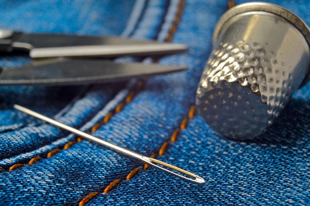 Close-up of a thimble of scissors and needles.