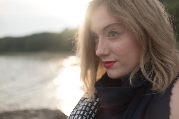 Foto close-up di una giovane donna bellissima e riflessiva sul mare