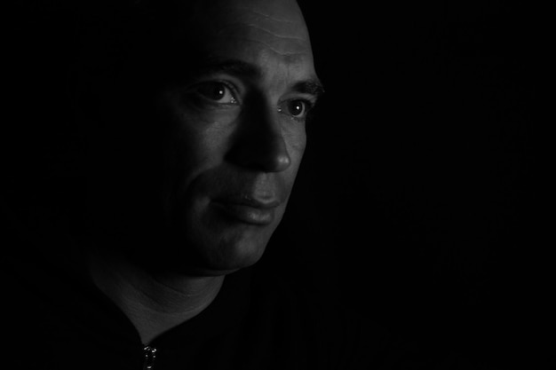 Close-up of thoughtful mature man against black background