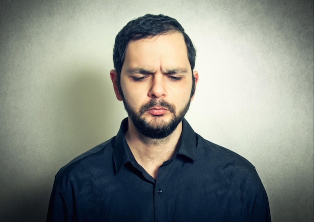 Photo close-up of thoughtful mid adult man against gray background