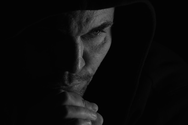 Close-up of thoughtful mid adult man with hand on chin against black background