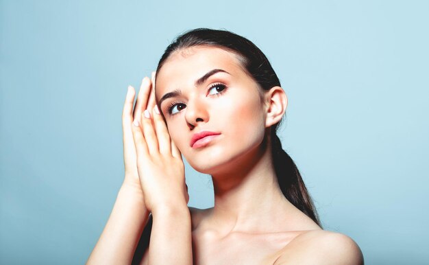 Close-up of thoughtful teenage girl against blue background