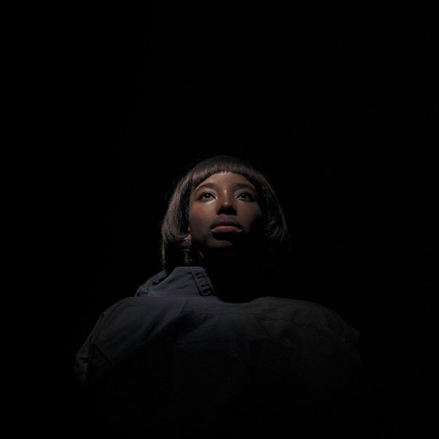 close-up of thoughtful young woman against black background
