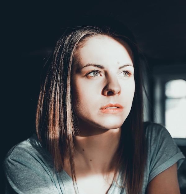 Photo close-up of thoughtful young woman looking away at home