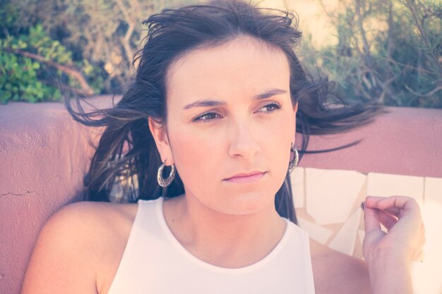 Close-up of thoughtful young woman sitting outdoors