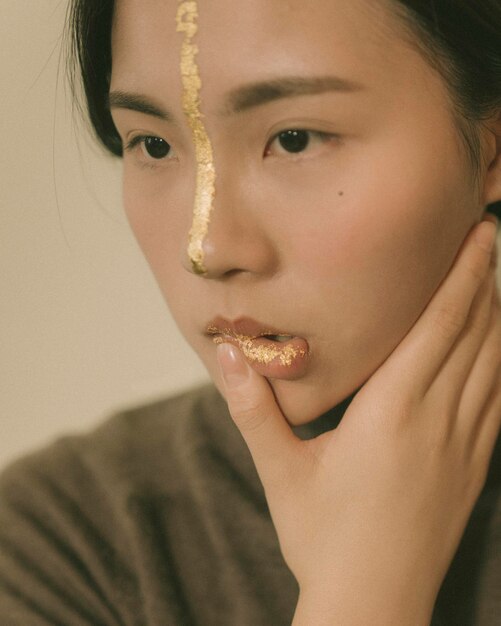 Photo close-up of thoughtful young woman with face paint