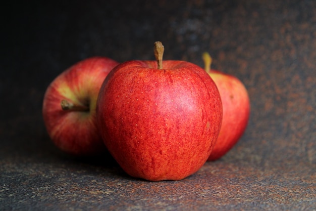 A close up of three apples on a table