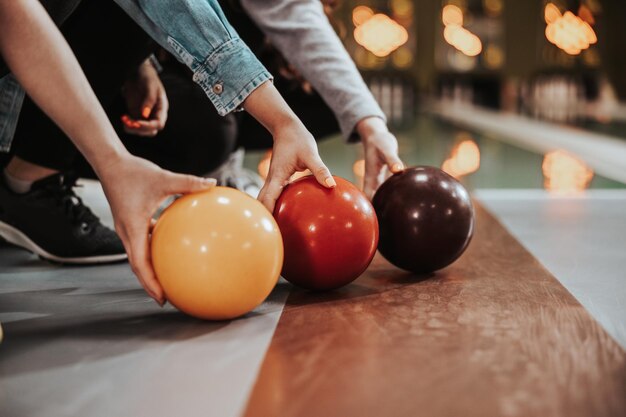 Close-up of a three female bowling players holding balls in the bowling club.