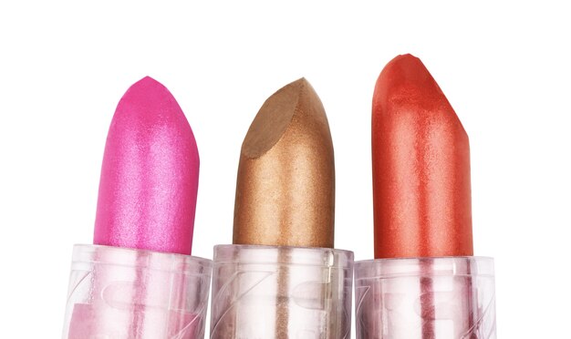 Close up of three lipsticks in different colors isolated on white