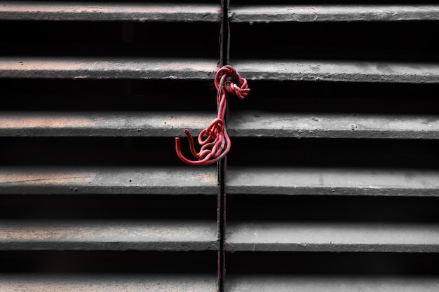 Photo close-up of tied hanging on rope against wall