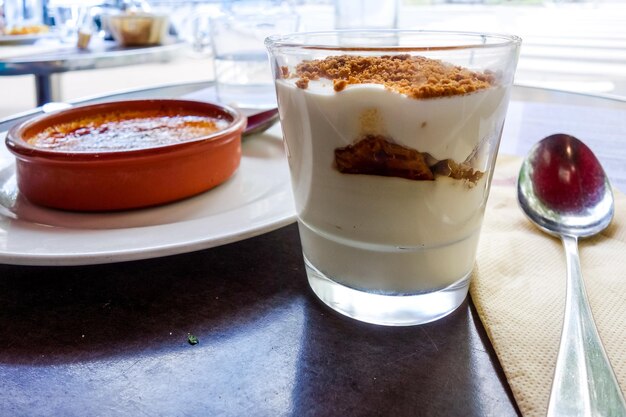 Foto close-up di tiramisu in bicchiere con creme brulee sul tavolo al ristorante