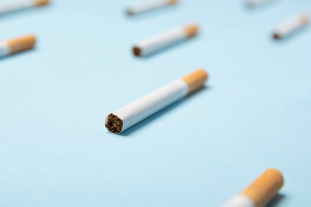 Close-up of tobacco cigarettes on blue pastel 