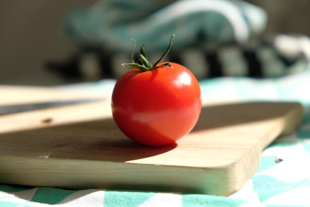 Foto prossimo piano di un pomodoro sul tavolino da taglio