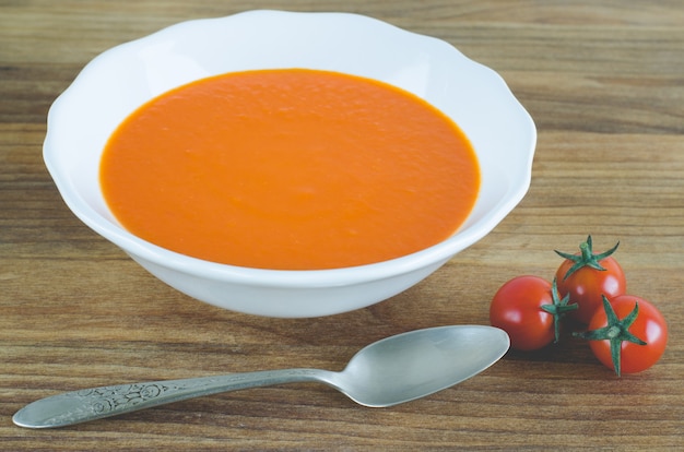 Photo close up on tomato soup with cherry tomatoes