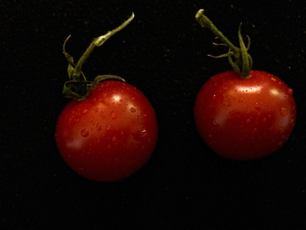 Photo close-up of tomatoes against black background