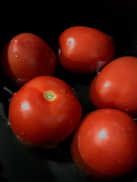 Foto prossimo piano di pomodori su sfondo nero