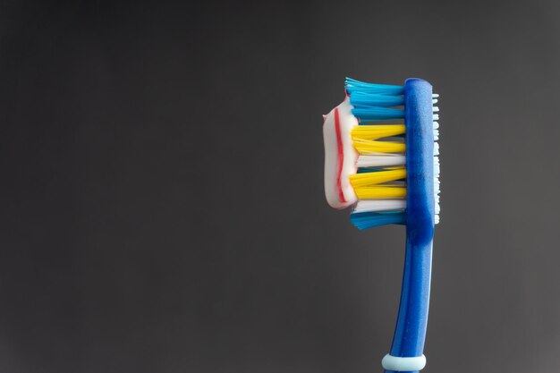 Close-up of toothbrush with toothpaste against gray background