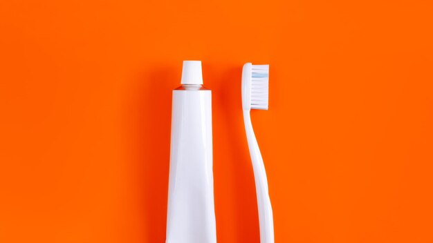 Photo close-up of toothbrush with toothpaste over orange background