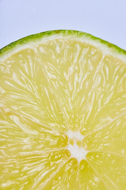 Close up of top curve of a lime slice on white background