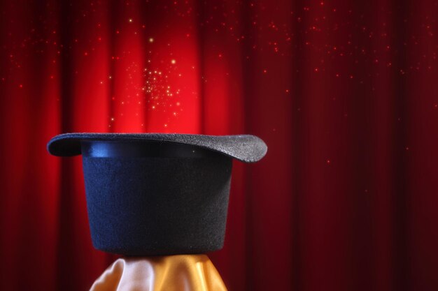 Close-up of top hat against red curtain