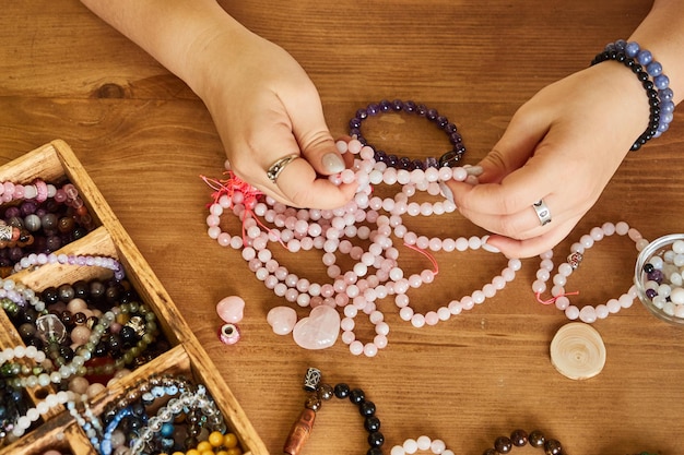 Close up top view of designer hand making rose quartz jewelry