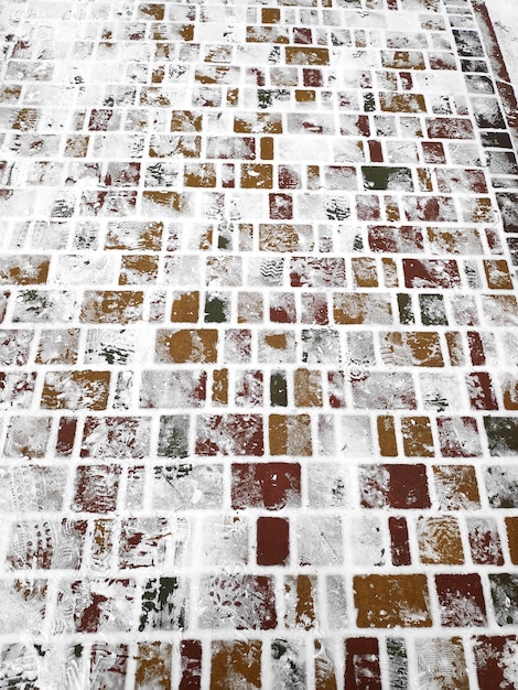 Крупным планом вид сверху следы на белом ледяном снегу бетонной поверхности тротуара фон Зимняя прогулка по улице на открытом воздухе концепция