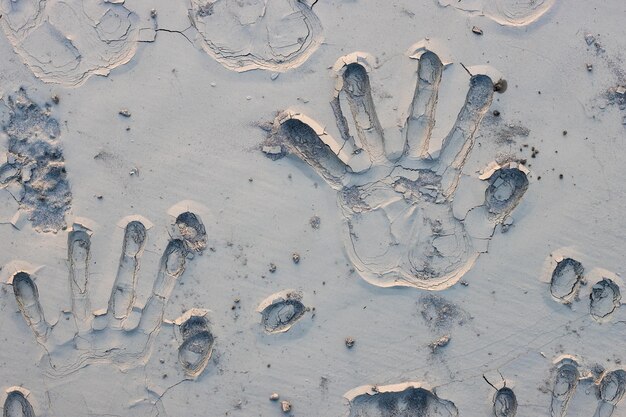 Photo close up top view of handprints on a sand land