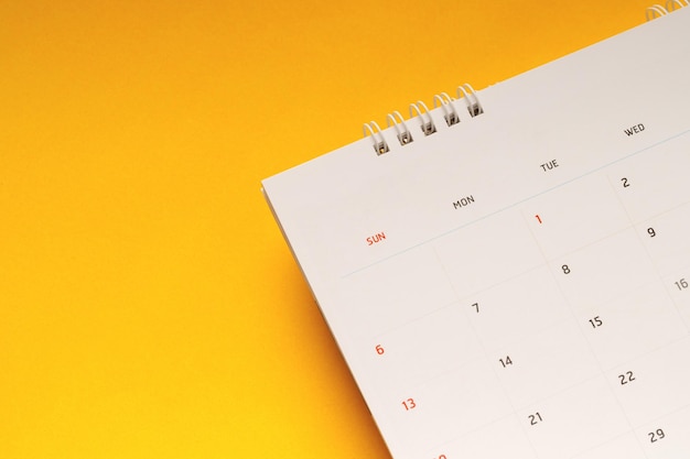 close up top view kalender schema om afspraken te maken vergadering of beheren tijdschema elke dag lag op gele achtergrond voor het plannen van werk en reis concept