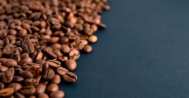 Close up top view of roasted coffee beans isolated on black background