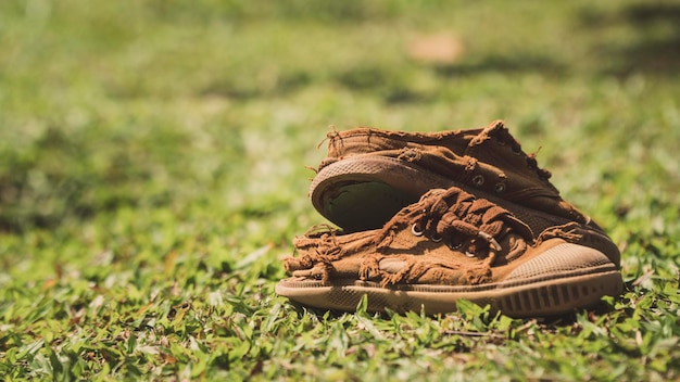 Photo close-up of torn shoes on field