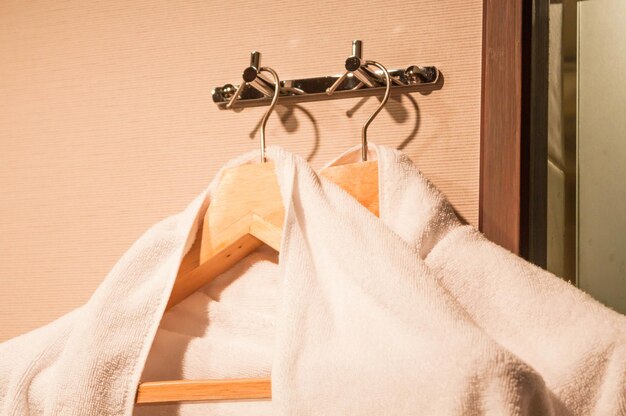 close-up of towels hanging on wooden coathangers from hooks at home